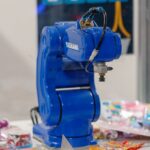 Een industriële robotarm uitgerust met 3D-camera's voor nauwkeurige productassemblage in een moderne fabriek.