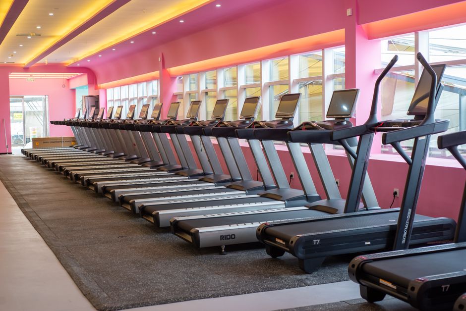Een vrouw die op een loopband traint in haar woonkamer, perfect voor thuisfitness.